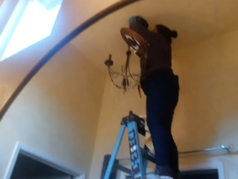 Electrician installing a chandelier in a Chesterfield residence